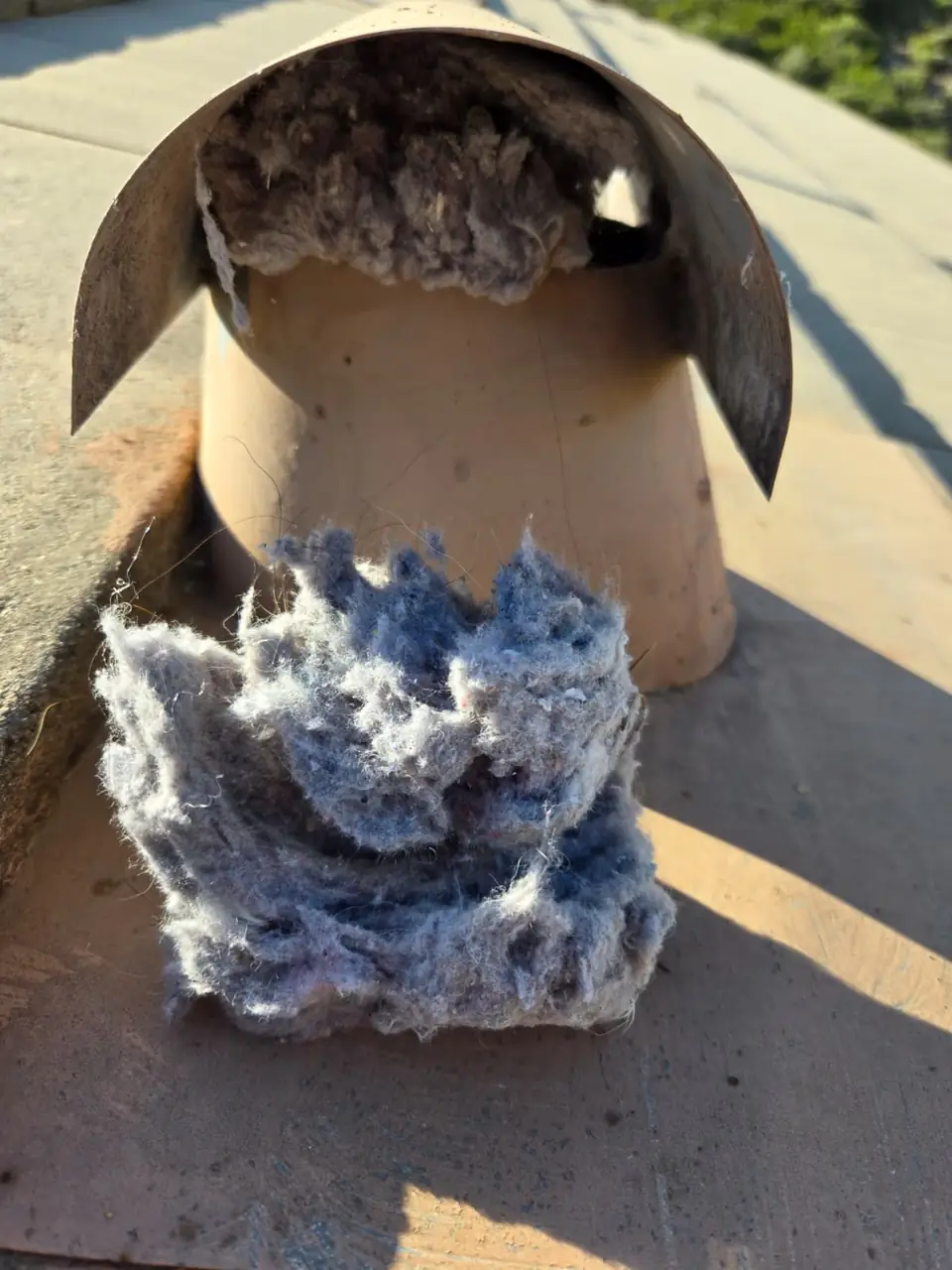 Roof dryer vent cap packed with lint