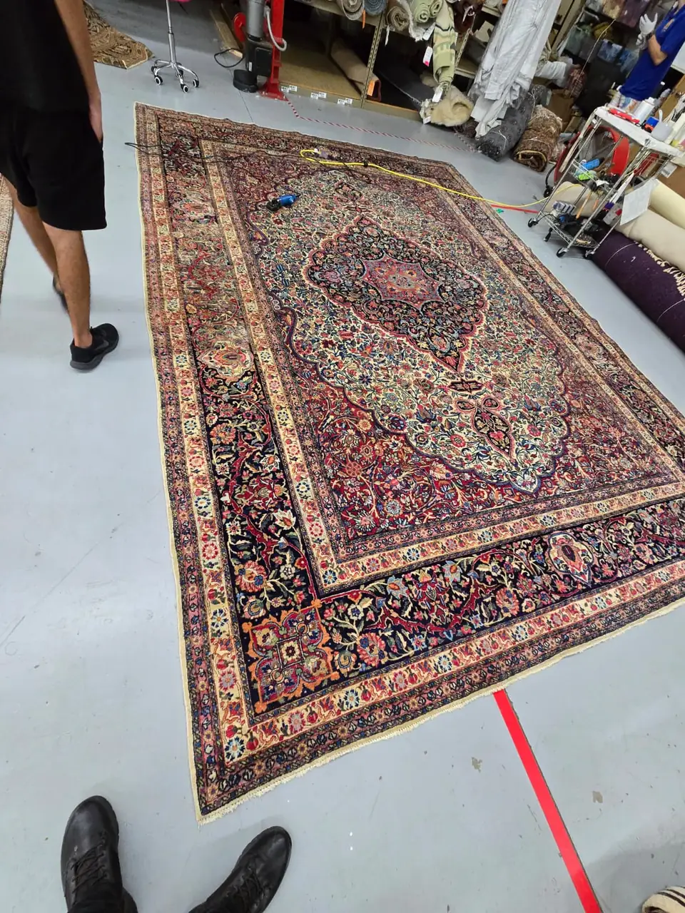 Persian rug laid out on the floor of a rug cleaning facility