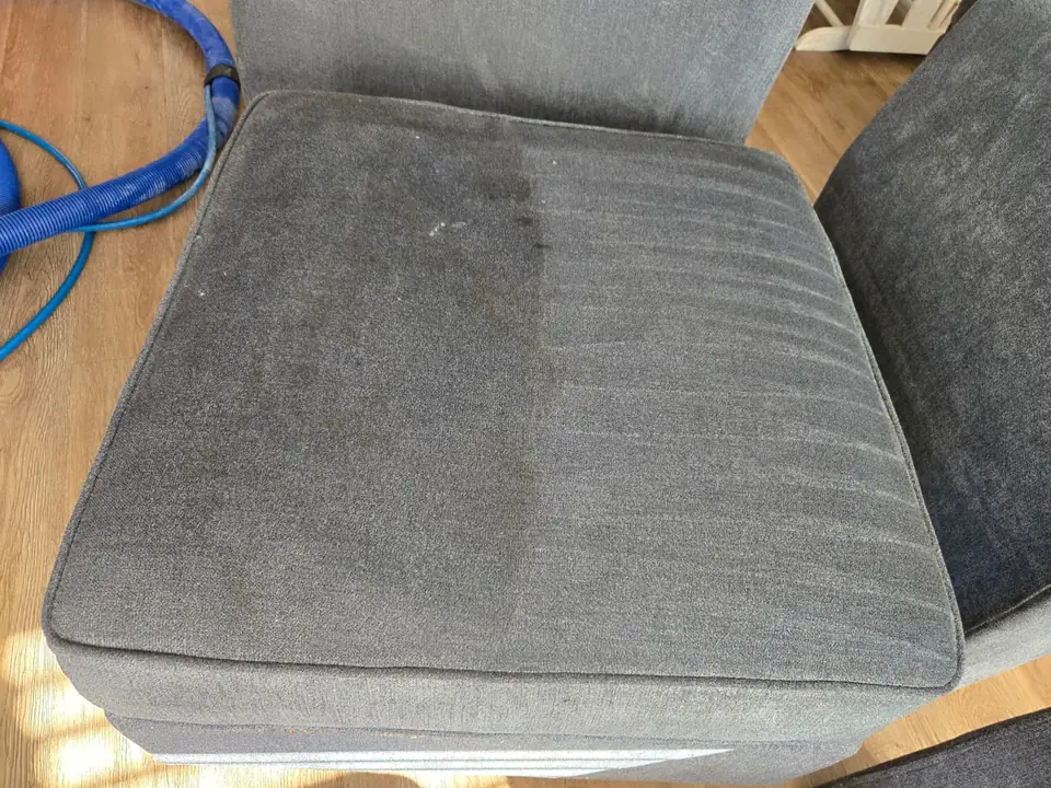 Gray sofa cushion, one half cleaned and one half not yet cleaned